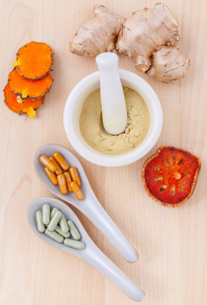 Esta imagem mostra ingredientes usados como suplementos naturais. Mostra a cúrcuma, gengibre e algumas pílulas.